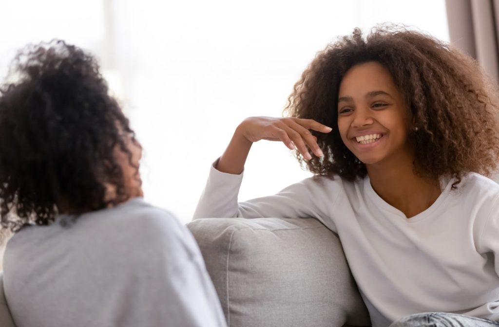 Young girl and her mother having a conversation while sitting on the couch
