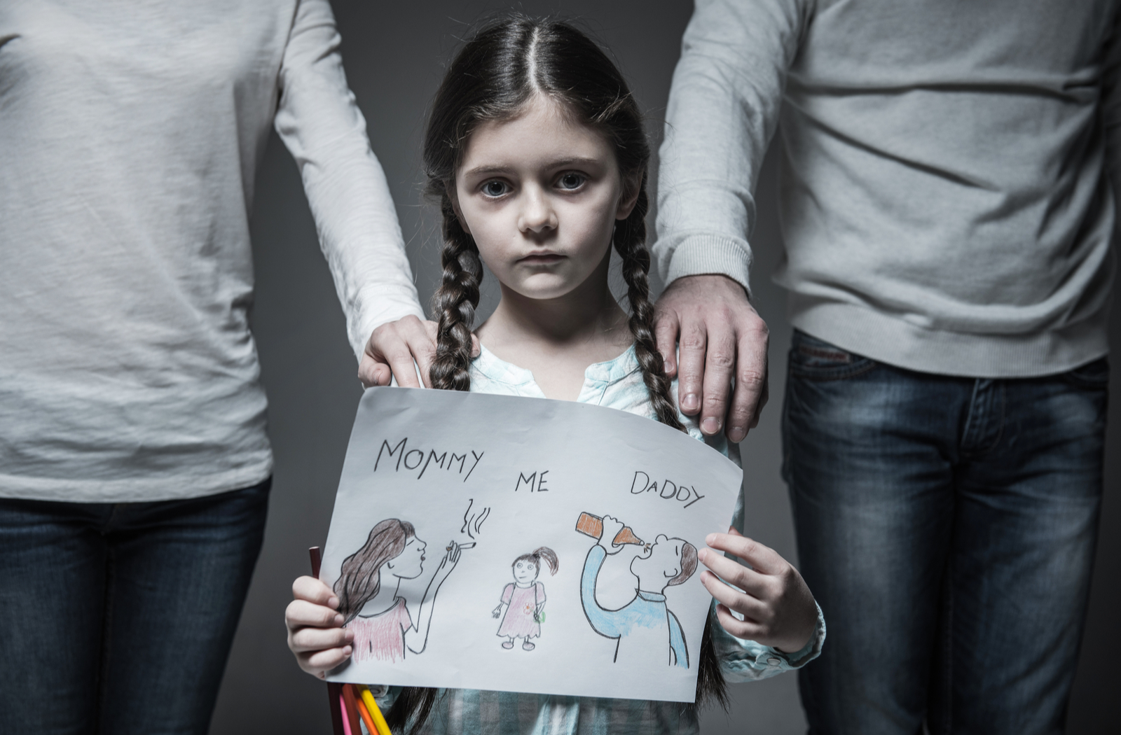 Sad girl standing in middle of parents concerned about mother and father with addiction