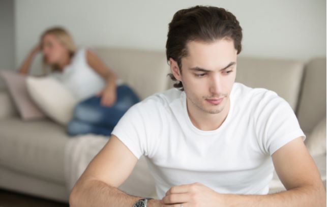 Stressed couple distancing themselves from one another due to drug addiction occurring in family.