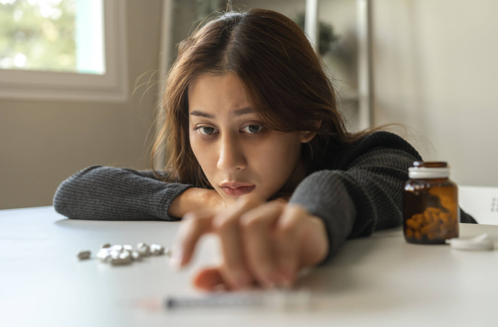 A stressed-looking young woman reached for a syringe on the table.